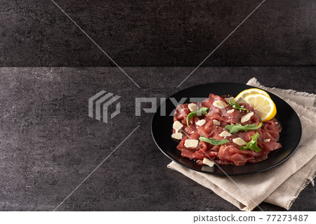 Marbled beef carpaccio on black plate Marbled beef carpaccio on black plate 77273487