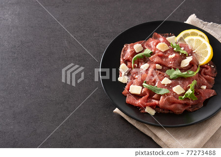 Marbled beef carpaccio on black plate Marbled beef carpaccio on black plate 77273488