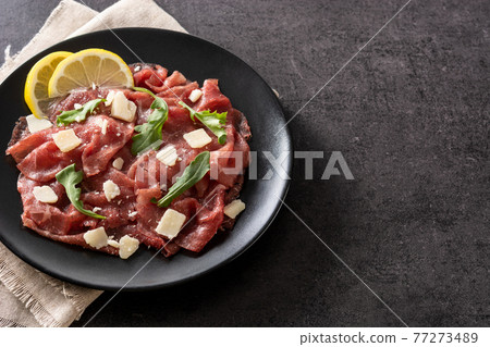 Marbled beef carpaccio on black plate 77273489