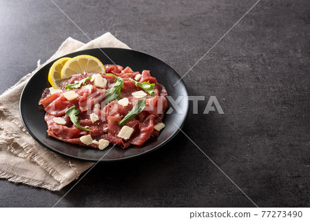 Marbled beef carpaccio on black plate Marbled beef carpaccio on black plate 77273490