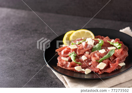 Marbled beef carpaccio on black plate Marbled beef carpaccio on black plate 77273502