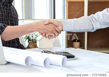 Team of architects or engineering shaking hands while working cooperation on engineer tools and construction drawings inspection, discussing planning architectural project on blueprint, model house 77274088