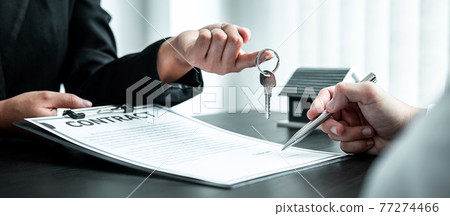 Estate agent are presenting home loan and sending keys to client after signing contract to rental house Insurance with approved property form 77274466