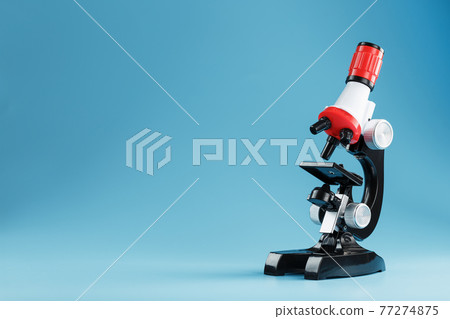 Microscope for laboratory medical research and experiments on a blue background. Microscope for laboratory medical research and experiments on a blue background. 77274875