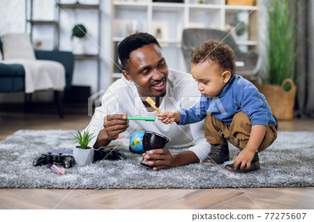 Young father and son drawing with pencils at home 77275607