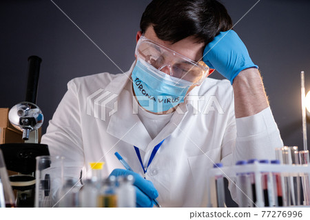 Exhausted doctor in medical mask with inscription coronavirus on it. The medical system is failing, healthcare workers are exhausted and sick with covid 19. Healthcare personnel medicine tired Exhausted doctor in medical mask with inscription coronavirus on it. The medical system is failing, healthcare workers are exhausted and sick with covid 19. Healthcare personnel medicine tired 77276996