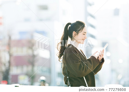 Young woman searching on her smartphone 77279808