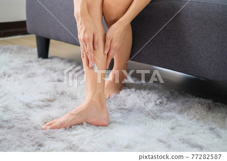Woman applying natural cream, Woman moisturizing her leg with cosmetic cream with copy space. 77282587