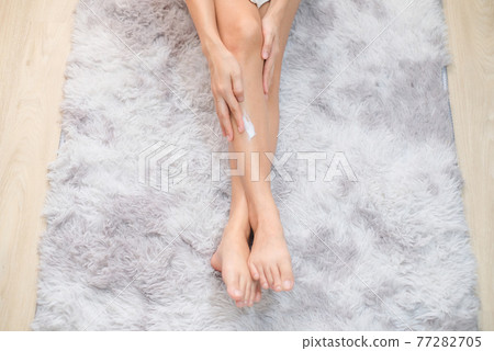 Woman applying natural cream, Woman moisturizing her leg with cosmetic cream with copy space, Top view. 77282705