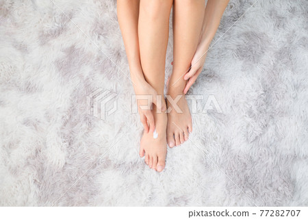 Woman applying natural cream, Woman moisturizing her leg with cosmetic cream with copy space, Top view. Woman applying natural cream, Woman moisturizing her leg with cosmetic cream with copy space, Top view. 77282707