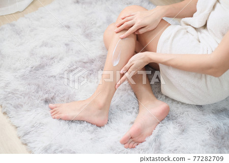 Woman applying natural cream, Woman moisturizing her leg with cosmetic cream with copy space, Top view. Woman applying natural cream, Woman moisturizing her leg with cosmetic cream with copy space, Top view. 77282709