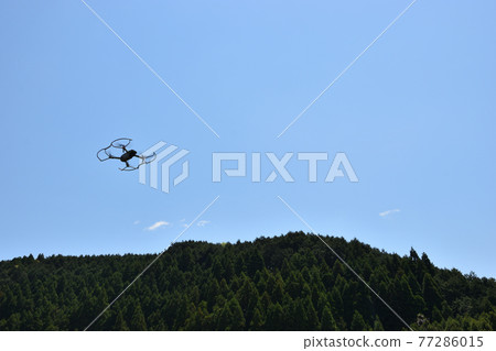 群山背景下，無人機在天空中飛翔 77286015