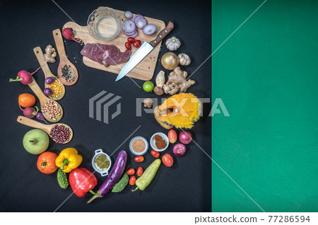 .top view Fresh food is placed on a black table with a green cloth on the side. 77286594