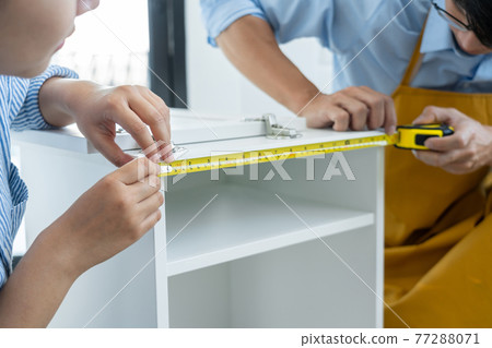Mechanic concept two officers assembling furniture together, preparing for their new office Mechanic concept two officers assembling furniture together, preparing for their new office 77288071