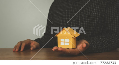 Business Finance insurance concept. Agent businessman Hold yellow paper house model. home loan mortgage to summary expense payment. family health live. financial real estate property investment. Business Finance insurance concept. Agent businessman Hold yellow paper house model. home loan mortgage to summary expense payment. family health live. financial real estate property investment. 77288733