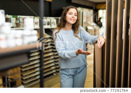 Female customer holding wooden panels samples in hardware store Female customer holding wooden panels samples in hardware store 77291764