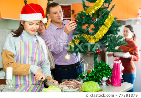 Woman cooking christmas dinner, family decoration christmas tree Woman cooking christmas dinner, family decoration christmas tree 77291879