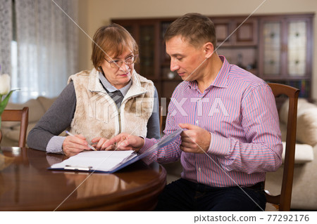 Man with elderly mother discussing documents Man with elderly mother discussing documents 77292176