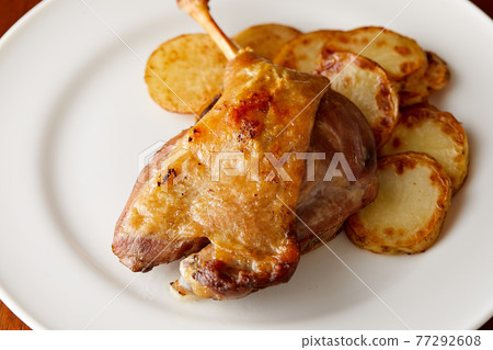 烤土豆配鴨肉,放在簡單的白盤上 烤土豆配鴨肉,放在簡單的白盤上 77292608
