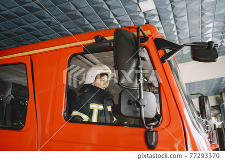 Firefighters in a fire truck in uniform Firefighters in a fire truck in uniform 77293370