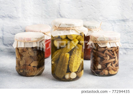 Preservation of vegetables in banks. Fermentation products. Harvesting cucumbers and mushrooms for the winter. Copy space. Preservation of vegetables in banks. Fermentation products. Harvesting cucumbers and mushrooms for the winter. Copy space. 77294435