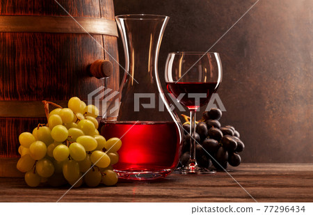 Wine decanter, glass of red wine and old wooden barrel 77296434