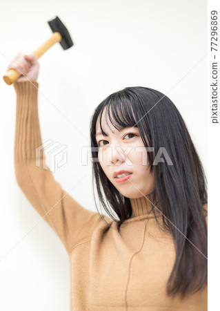 女人揮舞著一把錘子 女人揮舞著一把錘子 77296869