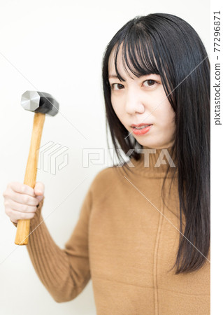 女人揮舞著一把錘子 女人揮舞著一把錘子 77296871