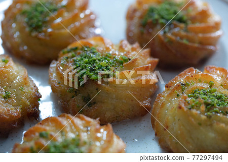 Turkish and Arabic Traditional Ramadan Dessert Lor Cheese Dessert with pistachio powder and syrup serving on plate. 77297494