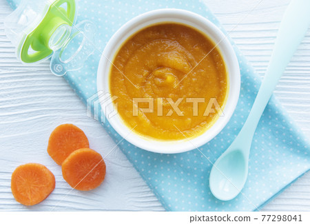 Baby carrot mashed with spoon in bowl 77298041