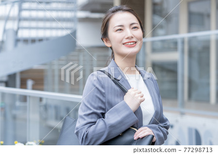 Business woman in a suit standing in front of the office Business woman in a suit standing in front of the office 77298713