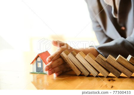 Protect the house from falling over the wooden blocks, Insurance and risk concept. Protect the house from falling over the wooden blocks, Insurance and risk concept. 77300433