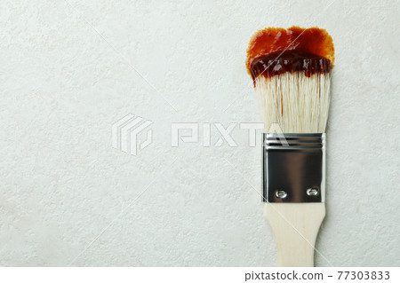 Brush with barbecue sauce on white textured background Brush with barbecue sauce on white textured background 77303833