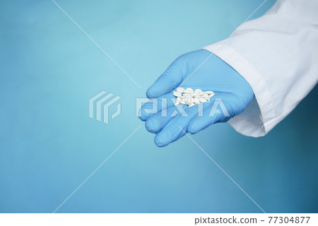 white color medical pills on hand  77304877