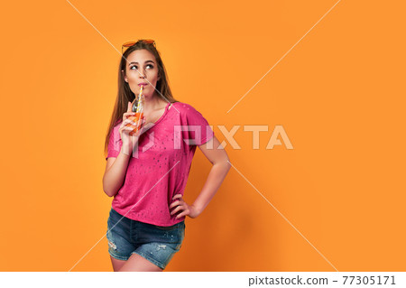 Happy young gen z girl holding drink wink look at camera wear sunglasses enjoy cool cocktail have fun isolated on yellow party summer studio background Happy young gen z girl holding drink wink look at camera wear sunglasses enjoy cool cocktail have fun isolated on yellow party summer studio background 77305171