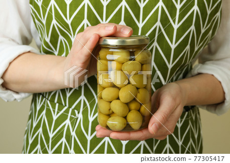 Woman hold jar of olives, close up 77305417