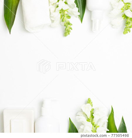 Spa bathroom products. Soap, shower towel, shampoo bottle with flowers on white background. top view, copy space 77305498