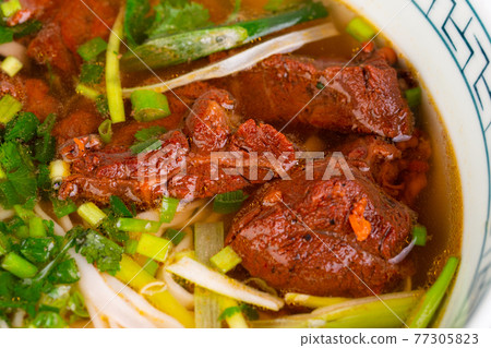 cooked beef with green onions, in cooked broth, served with greenery cooked beef with green onions, in cooked broth, served with greenery 77305823