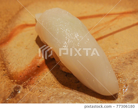 A piece of squid sushi on a beautiful pottery at a high class sushi restaurant in Ginza, Tokyo, Japan. A piece of squid sushi on a beautiful pottery at a high class sushi restaurant in Ginza, Tokyo, Japan. 77306180