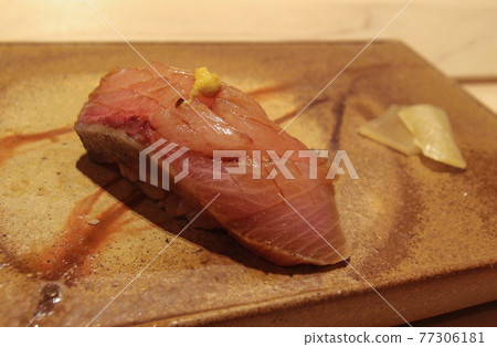A piece of sushi on a beautiful pottery at a high class sushi restaurant in Ginza, Tokyo, Japan. A piece of sushi on a beautiful pottery at a high class sushi restaurant in Ginza, Tokyo, Japan. 77306181