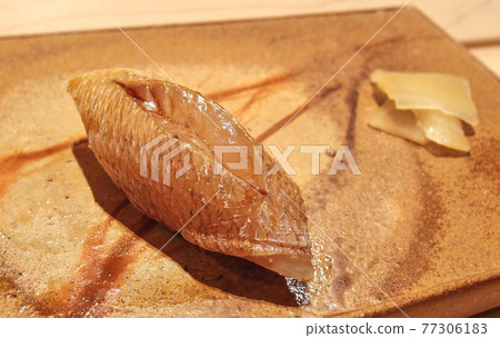 A piece of sea bream sushi on a beautiful pottery at a high class sushi restaurant in Ginza, Tokyo, Japan. A piece of sea bream sushi on a beautiful pottery at a high class sushi restaurant in Ginza, Tokyo, Japan. 77306183