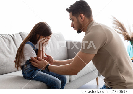 Little girl crying, upset young father consoling daughter 77306981