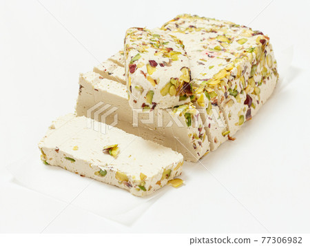 Halva with pistachios on white paper and background 77306982