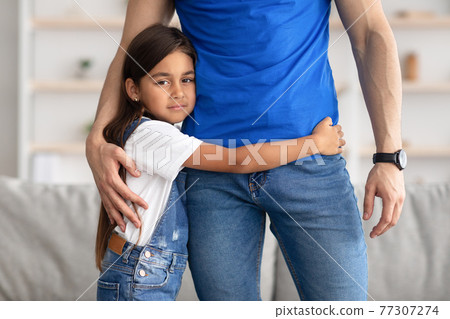 Portrait of father and daughter hugging at home Portrait of father and daughter hugging at home 77307274
