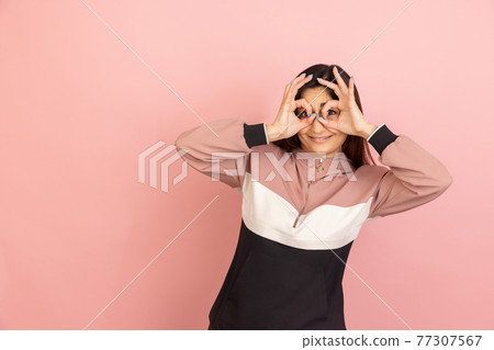 Young woman's portrait on pink studio background. Concept of human emotions, facial expression, youth, sales, ad. Young woman's portrait on pink studio background. Concept of human emotions, facial expression, youth, sales, ad. 77307567