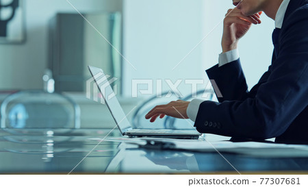 A businessman using a laptop in the office A businessman using a laptop in the office 77307681