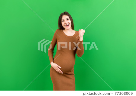 Young beautiful pregnant woman on isolated colored background celebrating surprised and amazed for success with arms raised and open eyes. Winner concept Young beautiful pregnant woman on isolated colored background celebrating surprised and amazed for success with arms raised and open eyes. Winner concept 77308009