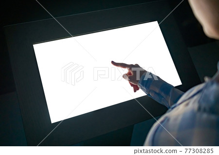 Woman touching interactive white blank touchscreen display kiosk at exhibition 77308285