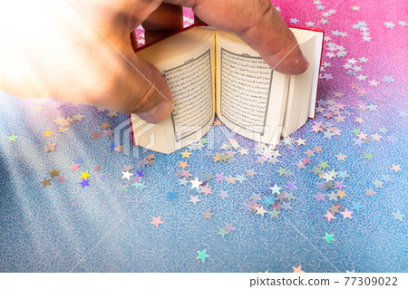Islamic Holy Book Quran in hand decorated with stars Islamic Holy Book Quran in hand decorated with stars 77309022