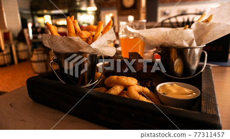 Beer set of snacks on a wooden tray. Snack for friends in a brasserie 77311457